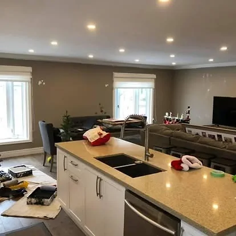 Living and kitchen area during preparation, with tools and unfinished wall details visible