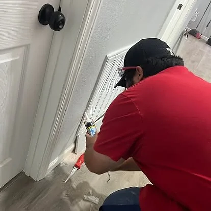 Technician applying a clean sealant bead beside trim