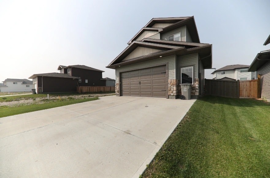Home with a finished concrete driveway and walkway