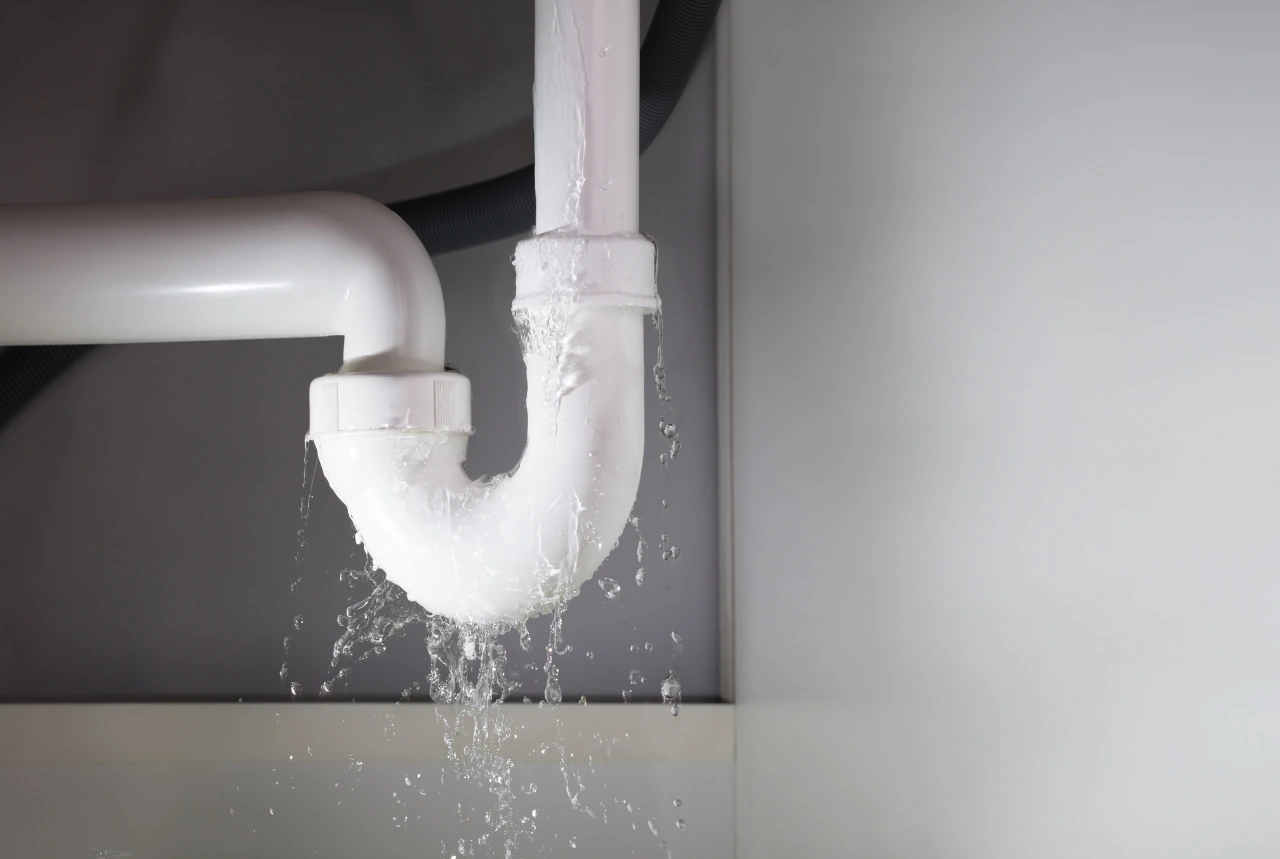 Water dripping from a leaking sink drain trap